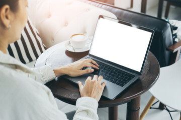 Fototapeta premium computer mockup blank screen.hand woman work using laptop with white background for advertising,contact business search information on desk at coffee shop.marketing and creative design