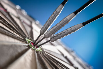 Darts in bullseye of dartboard concept for hitting target, perfection and success © Brian Jackson