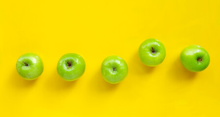 Green apples on yellow background.