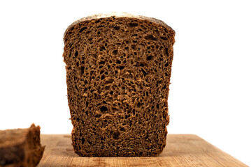A loaf of rye bread in a cut on a cutting board.