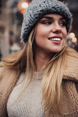 Happy young woman in outerwear looking away