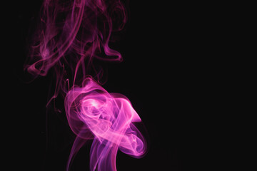 Fototapeta na wymiar Purple smoke on a black background. Colored smoke. Incense stick smoke illuminated by purple light.
