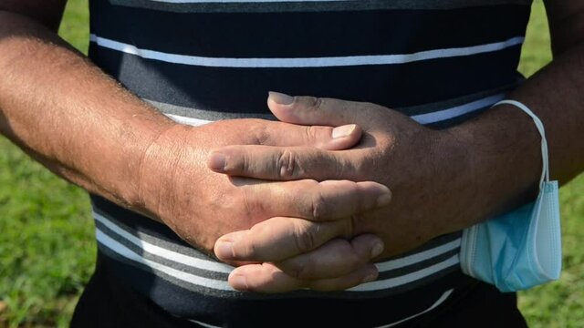 Praying hands of christian man praying in Cathedral. Catholic man praying with hands folded and fingers crossed. Male with hands crossed. Christianity and Religion.