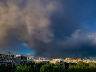 Sky with clouds over apartment buildings of the urban district. Panorama of the morning cityscape. Moscow city, Russia.