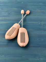 Wooden shoe lasts on a blue wooden background.