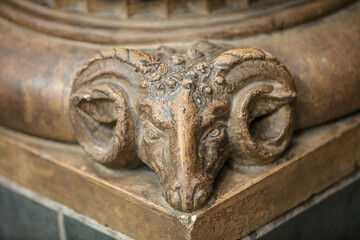 Detail of a rams head sculpture adorning a column in the Natural History Museum, London, UK
