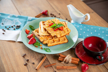 Breakfast with waffles, strawberries, mint and cinnamon