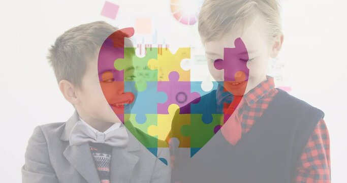 Jigsaw puzzle forming a heart against two boys holding a placard. Autism awareness animated video