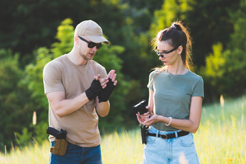 the instructor teaches the girl to shoot a pistol at the range