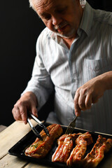 Selective focus. The chef places the marinated pork ribs on a baking sheet. Cooking the ribs.
