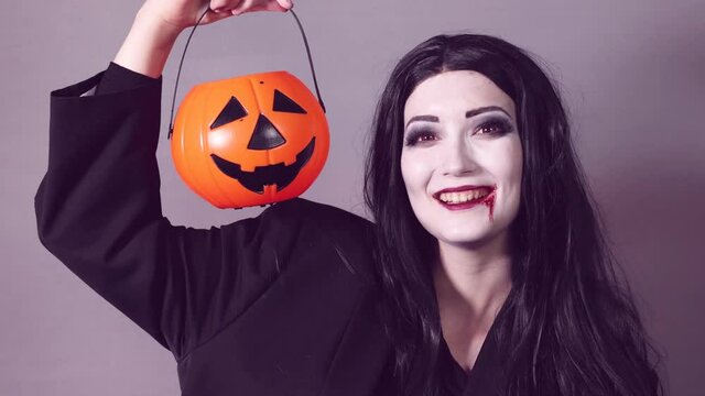 Young woman with halloween makeup and pumpkin basket