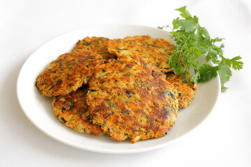 Zucchini patties close up with cilantro on a white background.