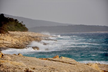 Big wave breaking on the rocks, splashing sea wave.