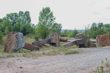 ancient concrete huge columns made of stone, with metal elements. Against the background of the forest. Environmental pollution with concrete.