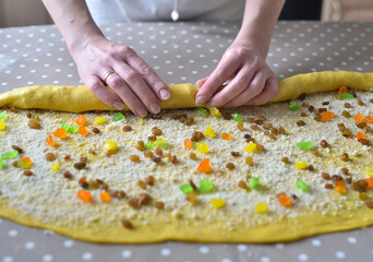 female hands twist the dough with raisins and candied fruits. raw cake dough