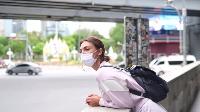 Lifestyle new normal concept. Young caucasian traveller woman with backpack and mask protect virus. Backpack traveling in city destination landmark     