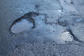 pot holes in asphalt road, construction and infrastructure repair