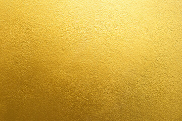 Gold wall texture background. Yellow shiny gold foil paint on wall surface with light reflection, - obrazy, fototapety, plakaty