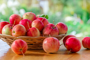 A captive vase filled with ripe red apples stands on an outdoor table in the garden. Harvesting. Thanksgiving Day. close up.