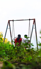 Romantic couple swinging on swings over the green mountain landscape with sky. Freedom concept. Touristic place. Khagrachhari, Bangladesh/ 2020.