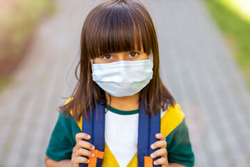 Little girl wearing anti virus mask going to school 
