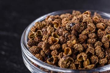 Sichuan pepper on a dark stone background