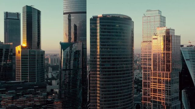 Drone shot of futuristic Moscow International Business Center. Financial district skyscrapers on sunset. The concept of success. the camera is going up. High quality 4k footage