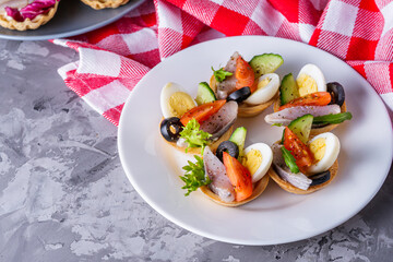 delicious snack tartlets on dark stone background
