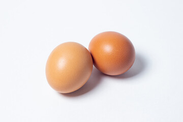 Eggs on a white background. Two chicken eggs lie next to each other
