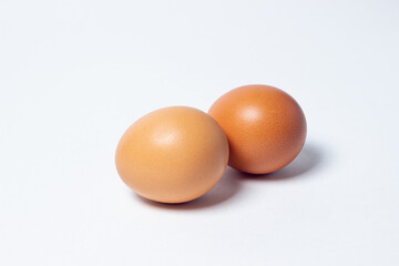 Eggs on a white background. Two chicken eggs lie next to each other