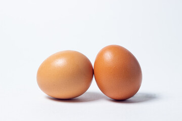 Eggs on a white background. Two chicken eggs lie next to each other