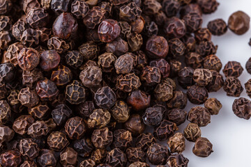 fragrant black pepper on white acrylic background