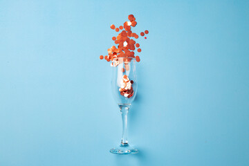 Champagne glass with confetti flat lay top view