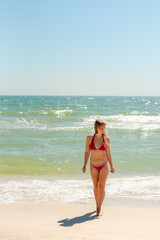 Fototapeta premium young woman walking on the beach