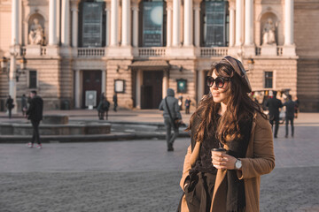 Naklejka premium portrait of stylish gorgeous woman in coat outdoors drinking coffee to go