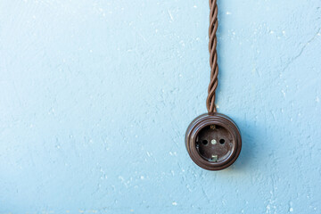 old brown european socket on blue wall, copy space