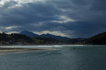 Playa con boya y montañas de fondo en temporal de tormenta