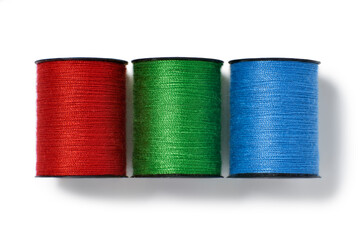 Overhead view of red,green and blue cotton reels isolated on white background
