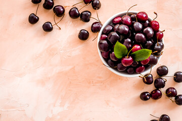 Layout of sweet cherries with leaves, top view, copy space