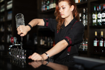Beautiful redhead barmaid making shots