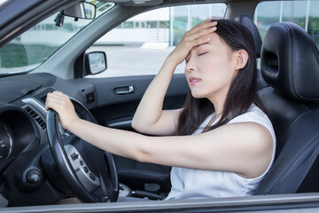 Fototapeta na wymiar Depressed woman driver sitting in her car, feeling emotional burnout after work. Chronic fatigue
