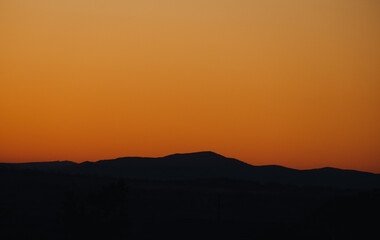Beautiful blazing sunset landscape at black sea and orange sky above it with awesome sun golden reflection on calm waves as a background. Amazing summer sunset view on the beach. Russian nature, Sochi