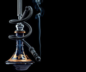 Beautiful hookah with a pipe curled in the shape of a black snake with a light smoke rising from it, isolated on a black background. Space for text.