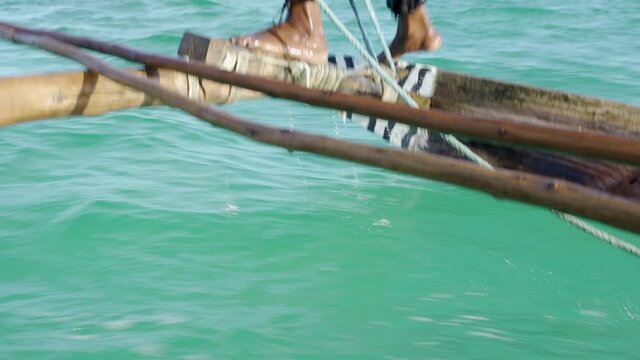 Outrigger sailing dhow travelling off the coast of Zanzibar. Tanzania. Africa.