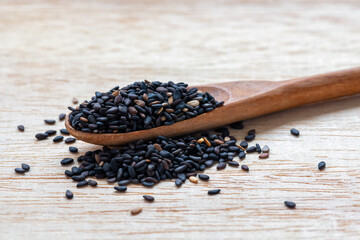Black sesame seeds in wooden spoon
