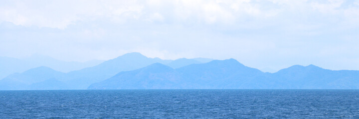 Obraz premium Blue sea with mountains and sky banner background.