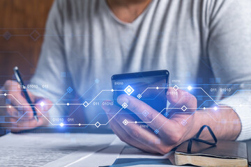 Obraz premium Double exposure of man signing contract with phone and technology hologram drawings. Concept of high-tech.