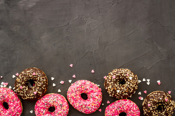Donuts flat lay pattern on dark background, top view