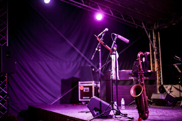 Saxophone Instrument on the Stage, photo close-up. Golden saxophone stands on the stage next to...