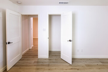 Doors in an empty bedroom leading to the livingroom and a closet